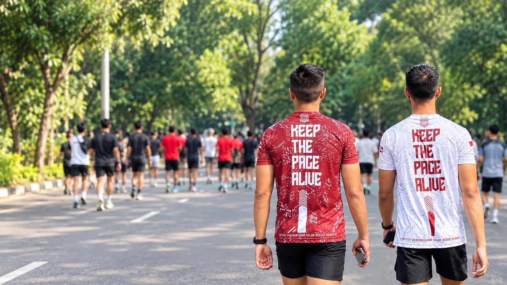Dua pelari memakai jersey IPDN Runners bertulisan Keep The Pace Alive
